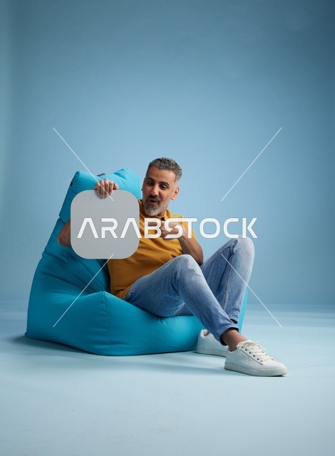 رجل سعودي يحمل لوحة موك أب فارغة في الاستوديو