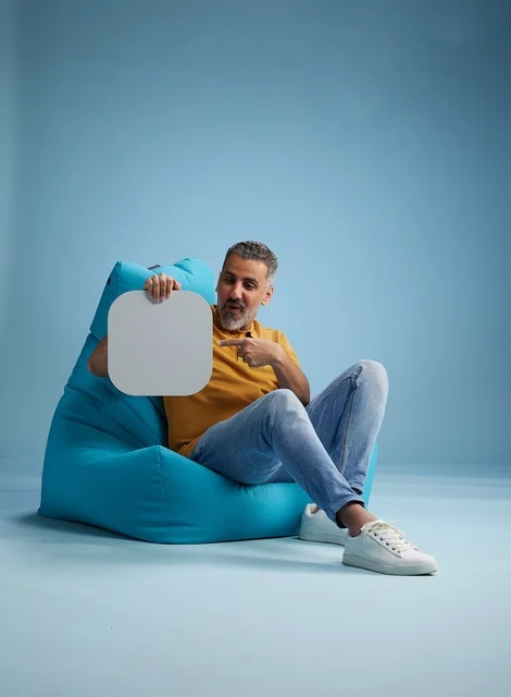 رجل سعودي يحمل لوحة موك أب فارغة في الاستوديو