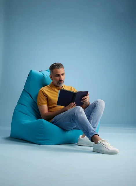 Saudi Man Reading Book on Blue Bean Bag