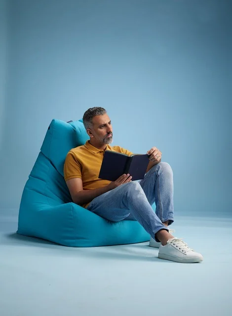 Saudi Man Reading a Book on Turquoise Beanbag Studio