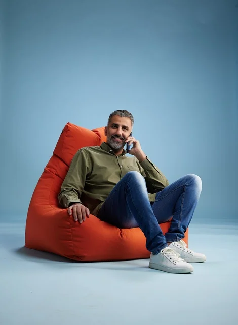 Saudi Man on Smartphone Sitting on Orange Beanbag