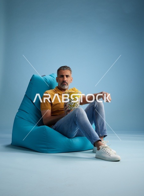 رجل سعودي مع فشار يجلس على بين باج أزرق