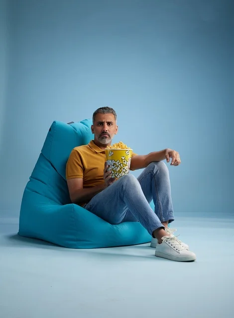 رجل سعودي مع فشار يجلس على بين باج أزرق