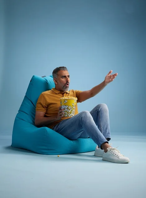 رجل سعودي يأكل الفشار على كرسي محشو