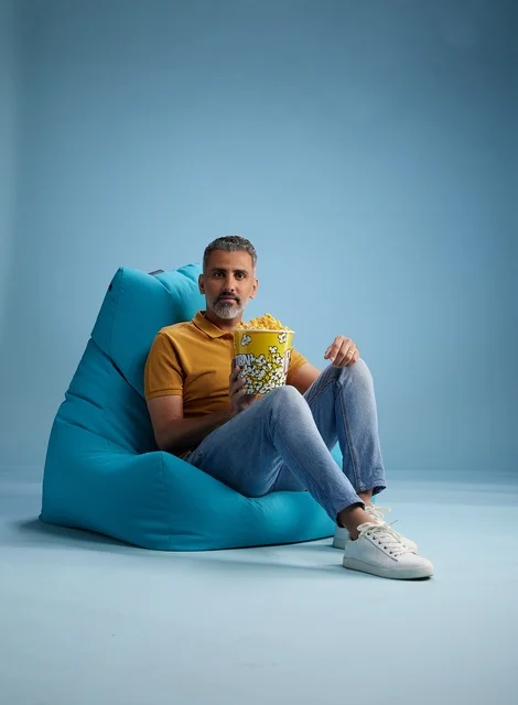 رجل سعودي مع فشار على مقعد محشو أزرق