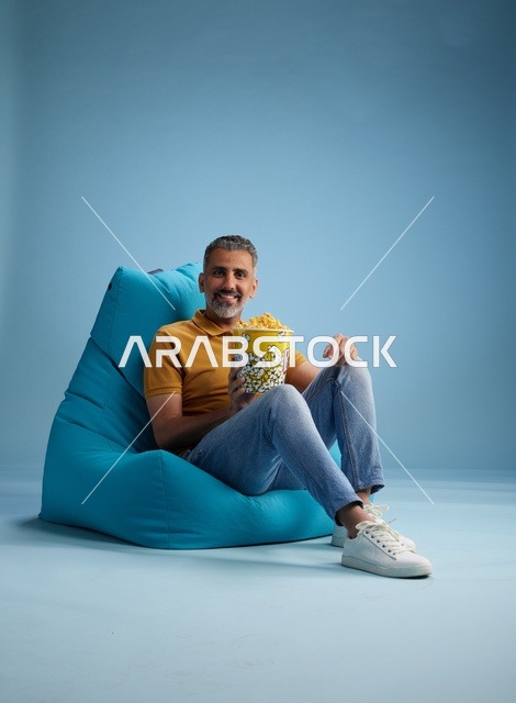 Saudi Man Eating Popcorn in Blue Bean Bag Chair Studio