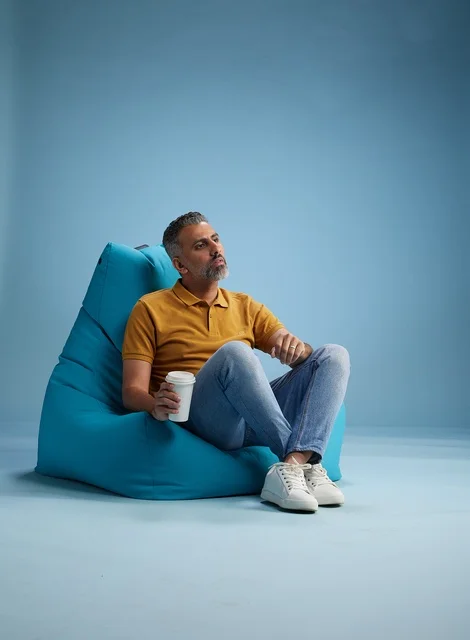 Saudi Man Relaxing on Beanbag with Coffee Cup