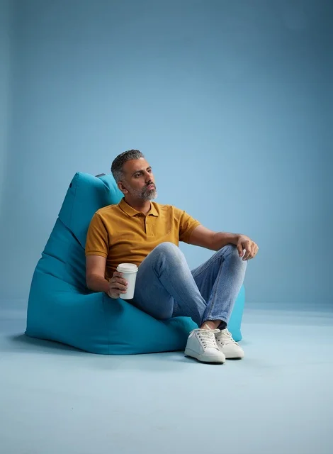 Saudi Man Relaxing in Bean Bag with Coffee Cup