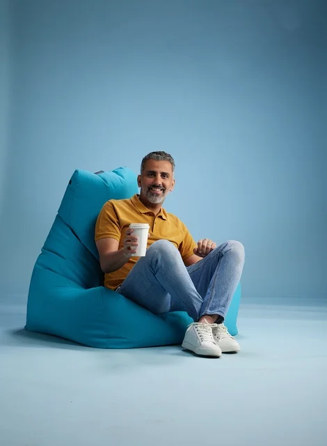 Saudi Man with Coffee on Beanbag Chair in Studio