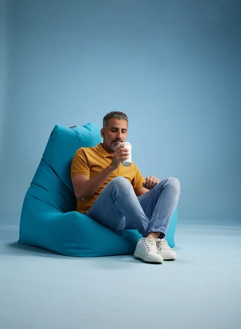 Saudi Man Relaxing on Bean Bag with Coffee Cup