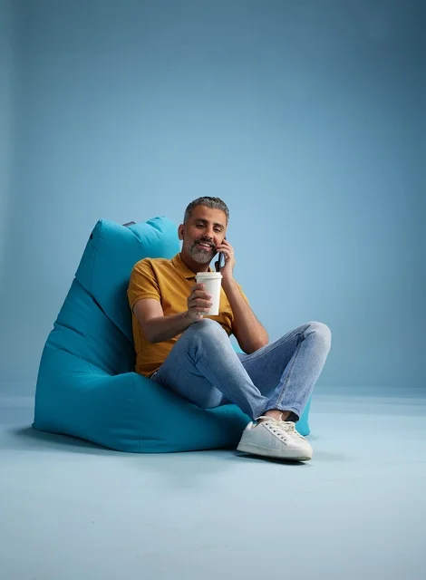 Saudi Man on Phone with Coffee on Blue Beanbag