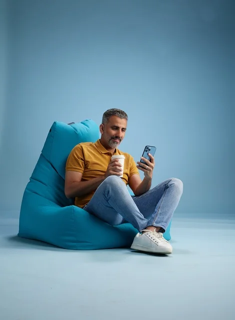 Saudi Man Relaxing on Bean Bag with Smartphone