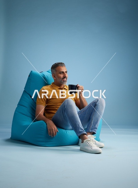 Saudi Man on Bean Bag with Coffee Cup