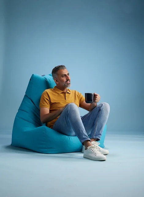 Saudi Man Relaxing in Bean Bag with Coffee Mug