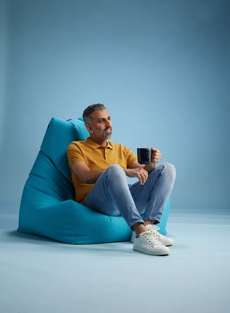 Saudi Man Relaxing on Beanbag with Coffee Mug