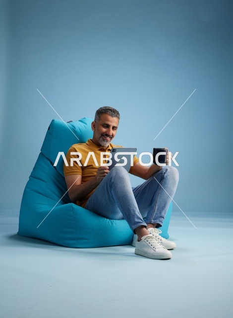 Saudi Man Using Tablet on Bean Bag Chair