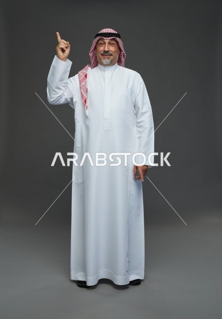 رجل سعودي بالزي التقليدي يشير للأعلى