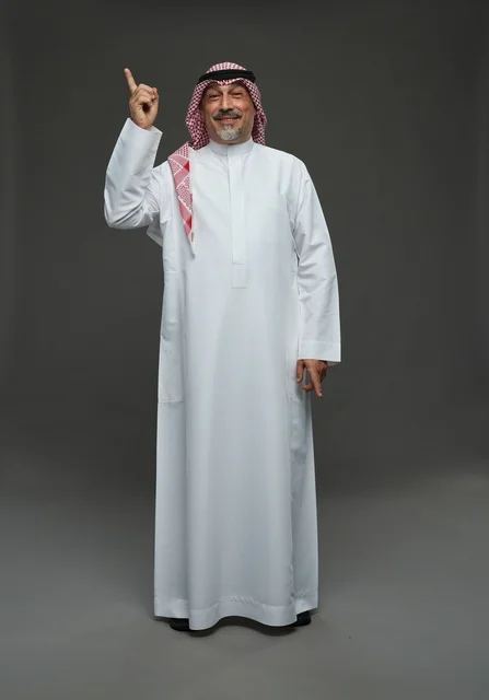 رجل سعودي بالزي التقليدي يشير للأعلى