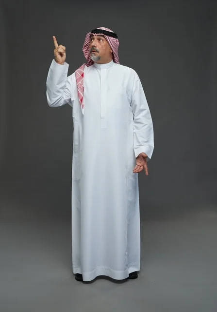 Saudi Man in Traditional Dress Pointing Up in Studio