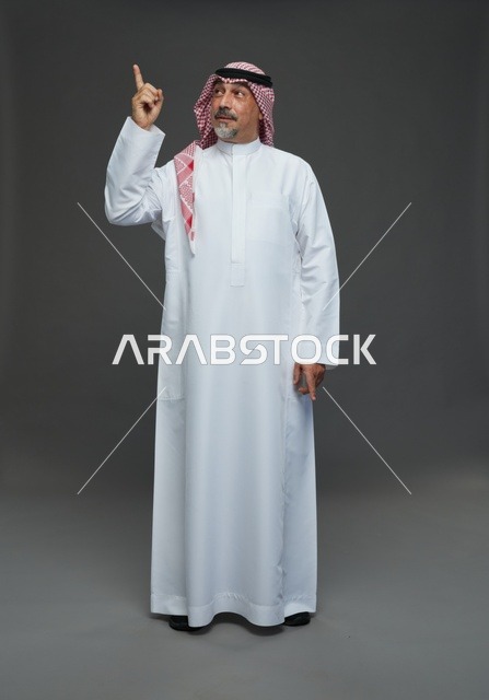 رجل سعودي بالزي التقليدي يشير للأعلى