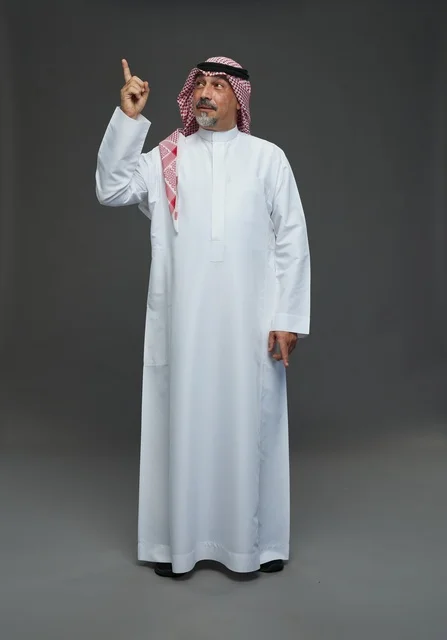 رجل سعودي بالزي التقليدي يشير للأعلى