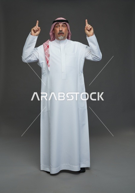 Saudi Man in Traditional Dress Pointing Upward Surprised