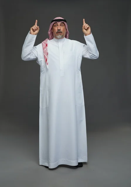 رجل سعودي بالزي التقليدي يشير للأعلى بتعبير متفاجئ رجل سعودي بالزي التقليدي يشير للأعلى بتعبير متفاجئ