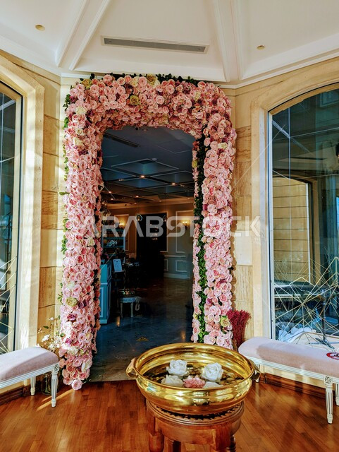 Creative image of a door surrounded by flowers in the Kingdom of Saudi Arabia, the door of a supplier, events and weddings, the entrance to a restaurant and cafe