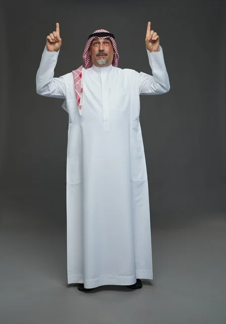 Saudi Man in Traditional Thobe Pointing Upwards Studio