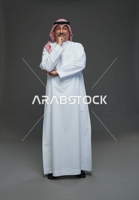 رجل سعودي بالزي التقليدي الثوب والشماغ في خلفية رمادية