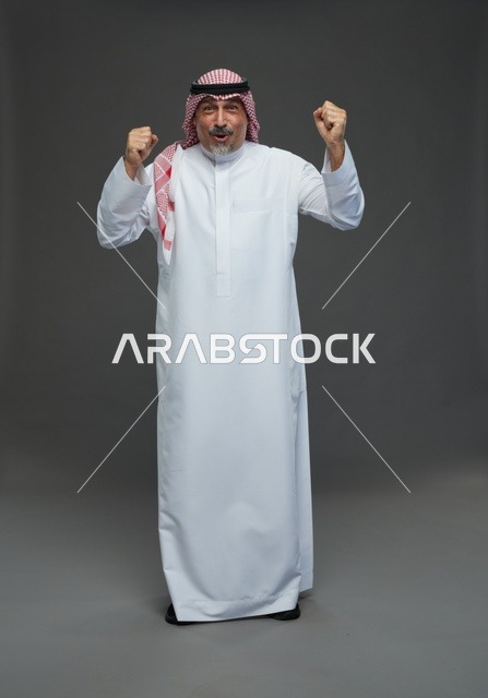 رجل سعودي بالزي التقليدي يحتفل بالفوز والنجاح
