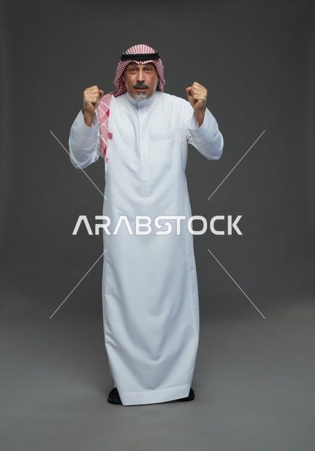 رجل سعودي بالزي التقليدي يحتفل بالفوز في استوديو