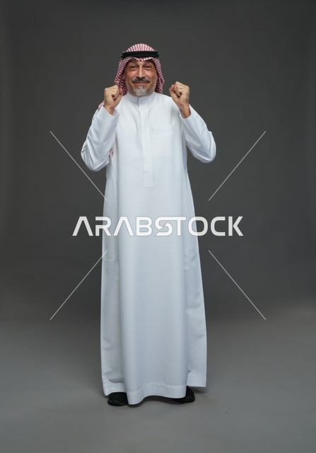 Saudi Man in Traditional Dress Celebrating Success Studio