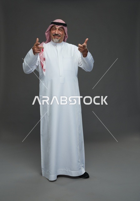 رجل سعودي بالزي التقليدي يشير بيديه في الاستوديو