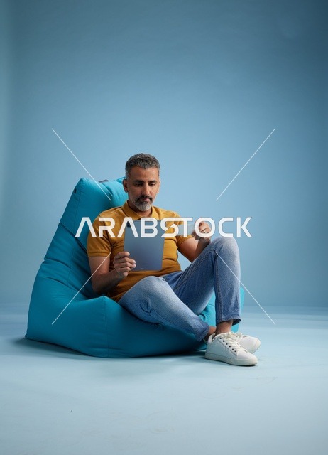 Saudi Man Online Shopping with Tablet and Credit Card