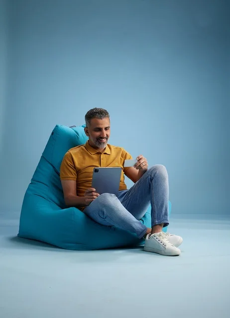 رجل سعودي يستخدم جهاز لوحي وبطاقة ائتمان للتسوق الإلكتروني