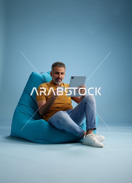 Saudi Man Using Tablet and Credit Card for Shopping