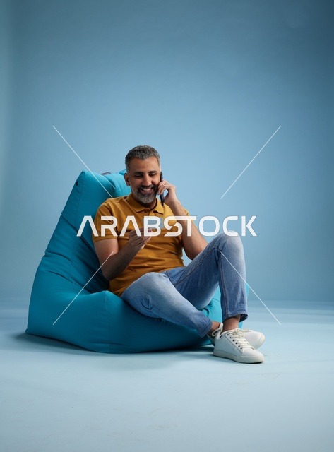 رجل سعودي يحمل بطاقة ائتمان وهاتف في الاستوديو