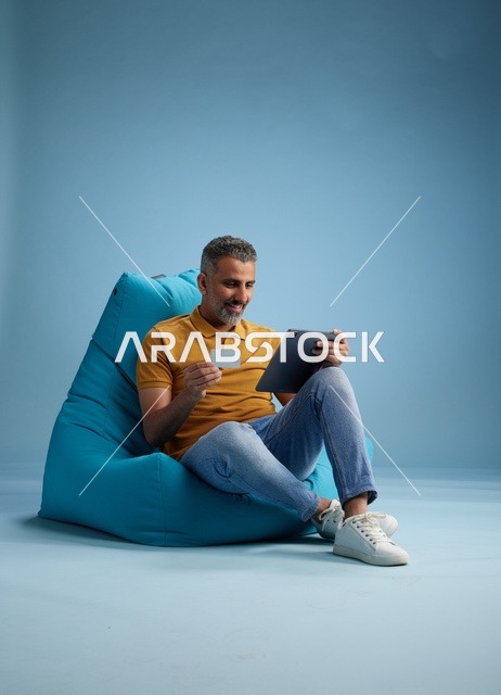 Saudi Man Using Tablet and Credit Card for Shopping