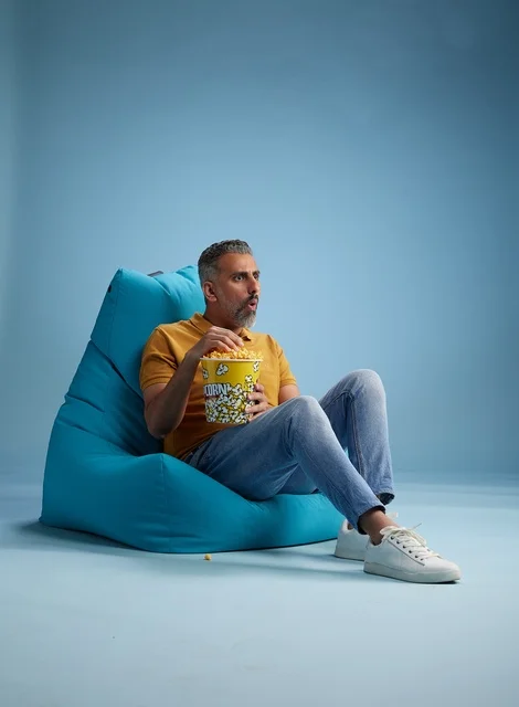 Saudi Man Eating Popcorn on Blue Bean Bag Chair