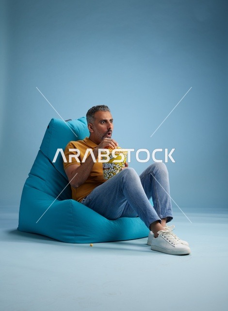 رجل سعودي يأكل الفشار على مقعد محشو