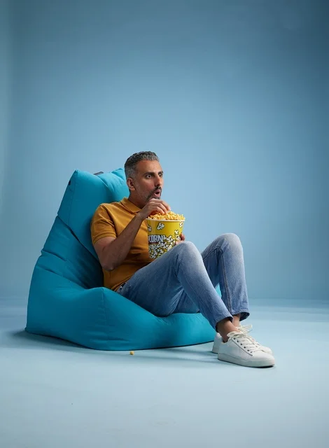 رجل سعودي يأكل الفشار على مقعد محشو