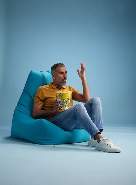 Saudi Man Eating Popcorn on Bean Bag Studio Background Saudi Man Eating Popcorn on Bean Bag Studio Background