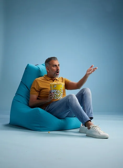 رجل سعودي يأكل الفشار مع تعبير وجه مندهش