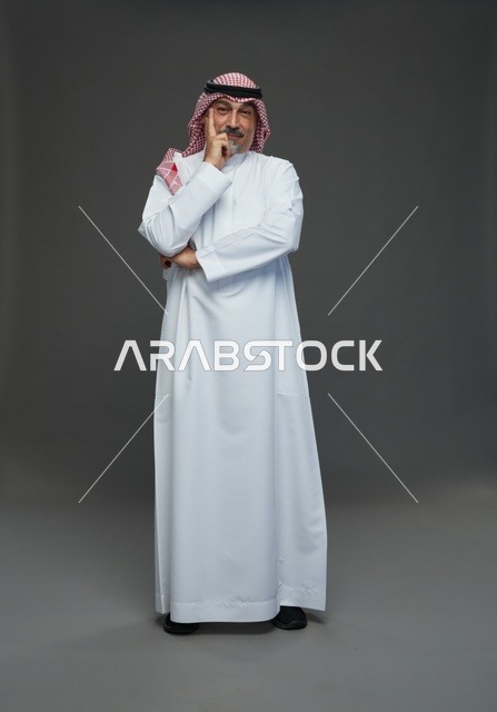 رجل سعودي بالزي التقليدي بوضعية تفكير في الاستوديو