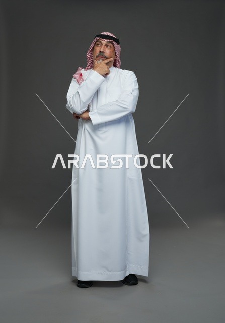 رجل سعودي بالزي التقليدي في وضعية تفكير داخل استوديو