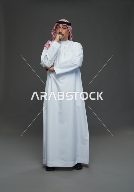 رجل سعودي بالزي التقليدي في وضعية تفكير في الاستوديو