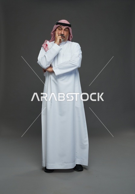 رجل سعودي بالزي التقليدي بوضعية تفكير في الاستوديو