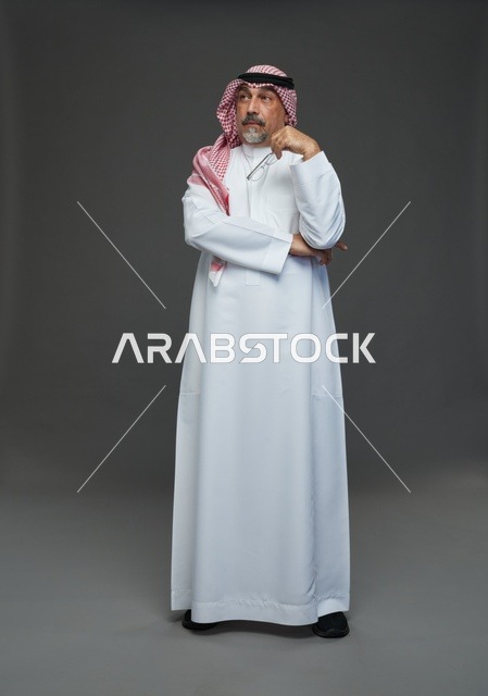 رجل سعودي بالزي التقليدي في وضعية تفكير بالاستوديو