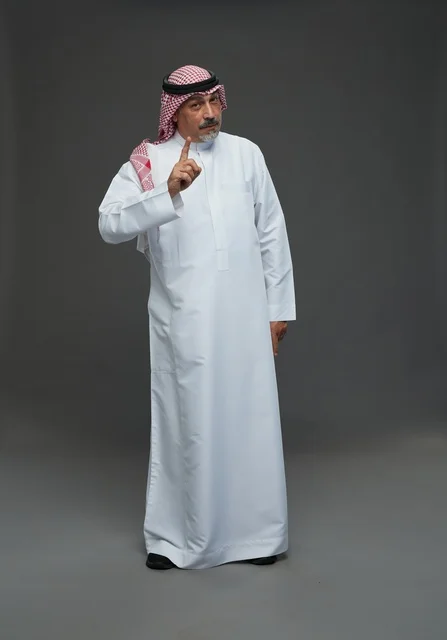 رجل سعودي بالزي التقليدي يشير بإصبع السبابة